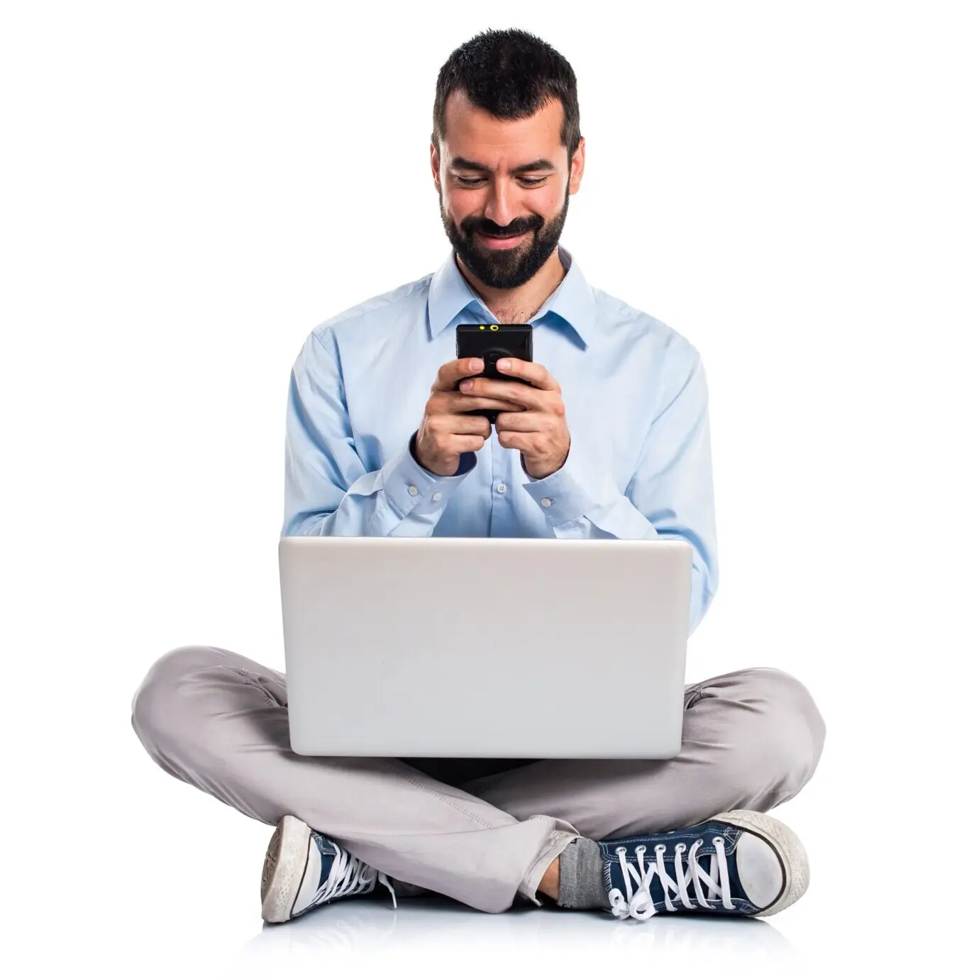 Mann mit Laptop, der am Handy spricht.